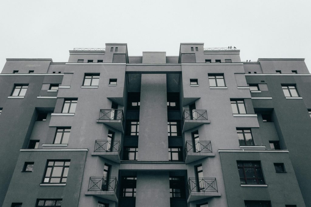Low-angle view of a minimalist apartment facade, showcasing modern architectural design and symmetry.